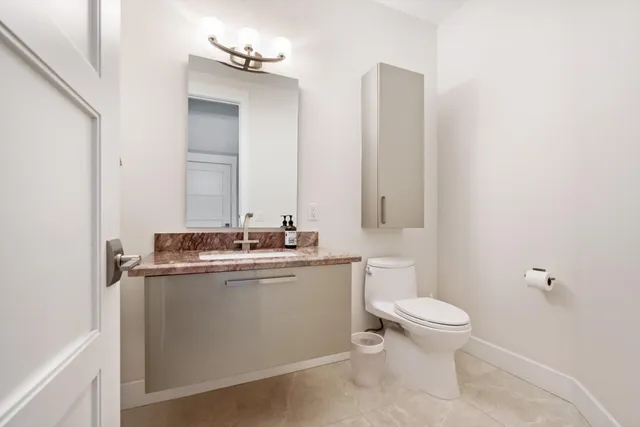 a bathroom with a granite countertop sink a toilet and a mirror