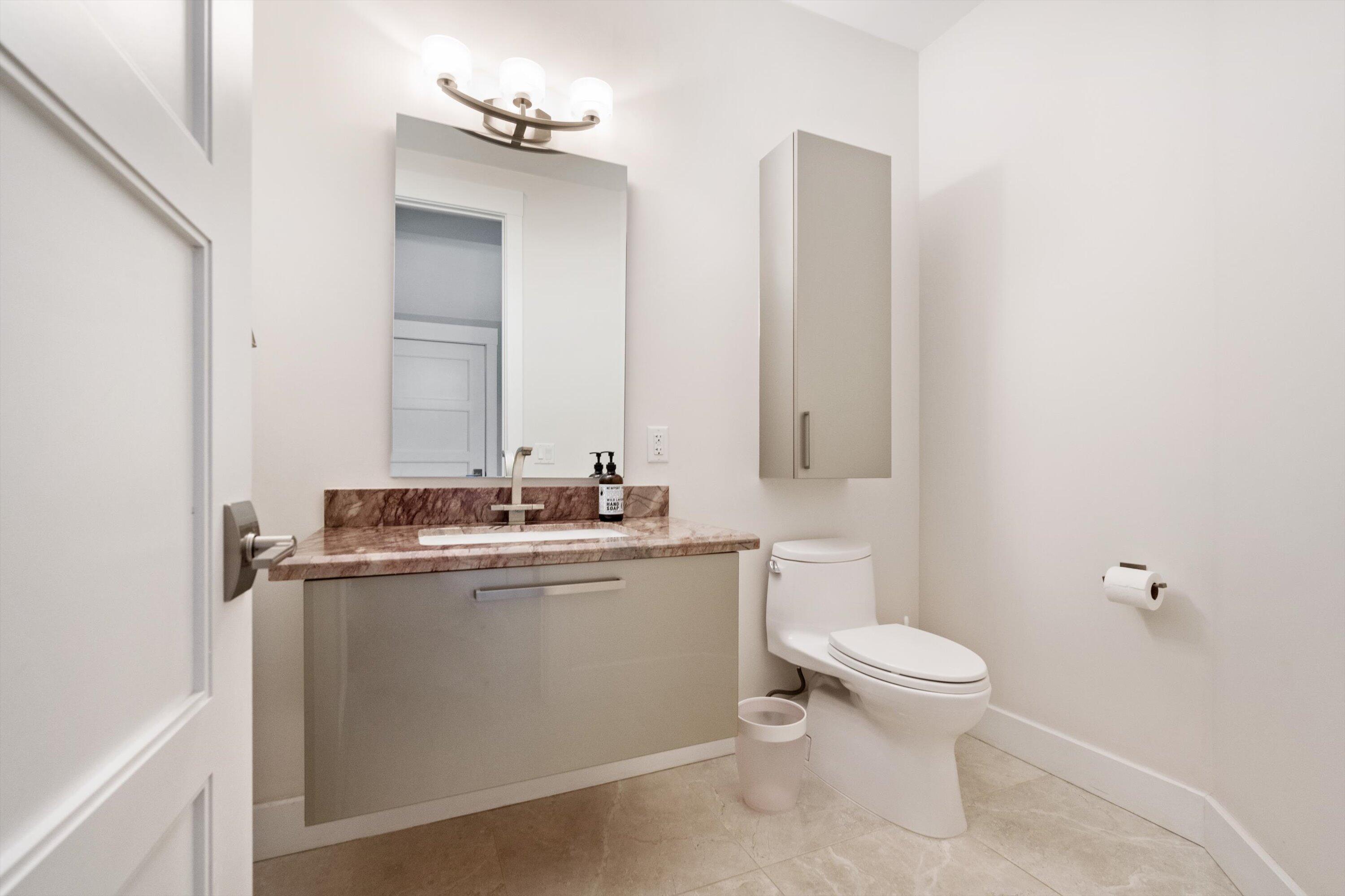 15880 Barnstormer Court Wellington, FL 33414 - Photo 36 of 48 a bathroom with a granite countertop sink a toilet and a mirror