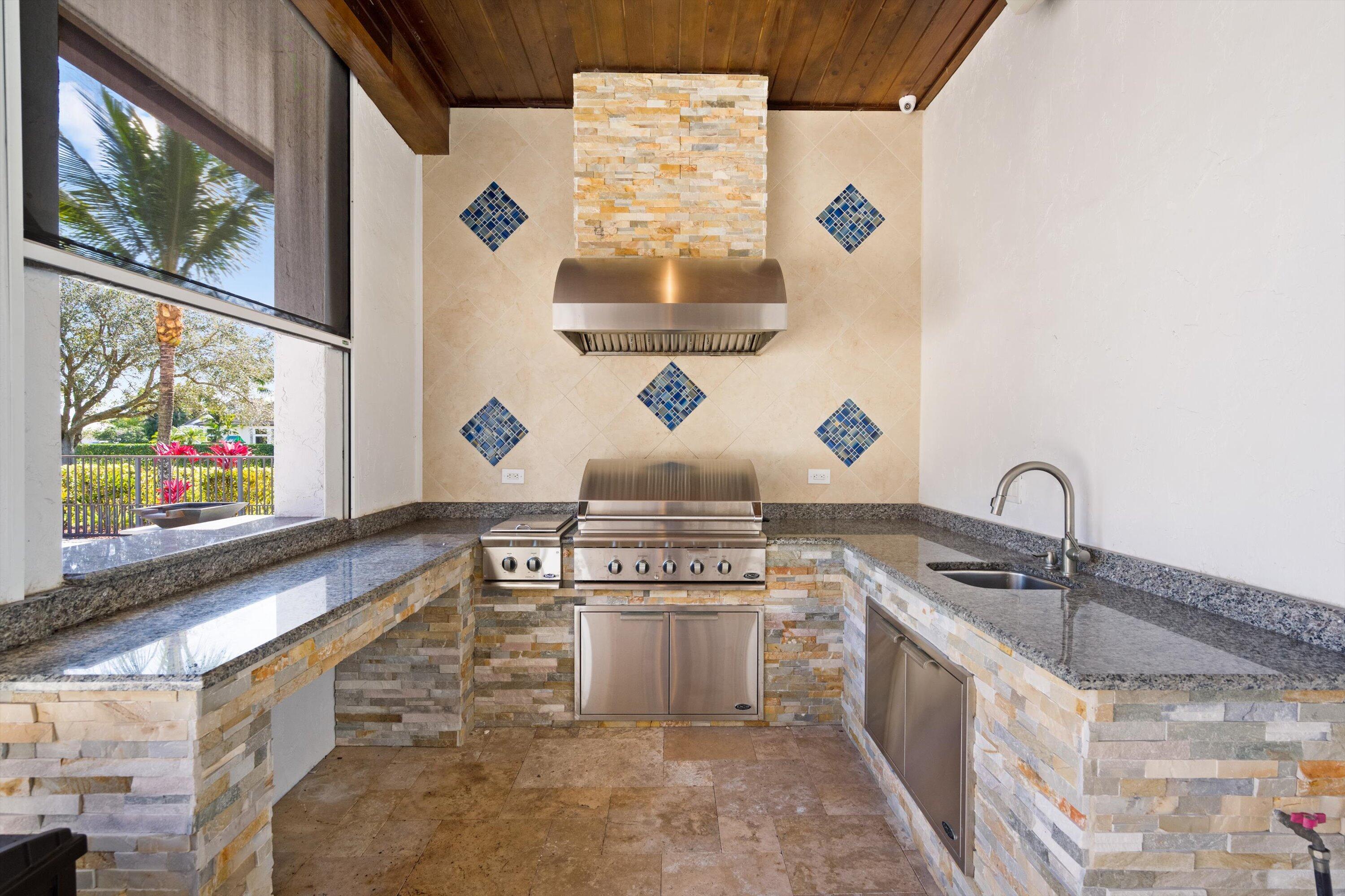 15880 Barnstormer Court Wellington, FL 33414 - Photo 40 of 48 a kitchen with stainless steel appliances granite countertop a sink and a microwave