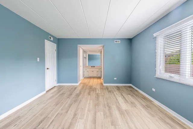 a view of a big room with wooden floor and windows