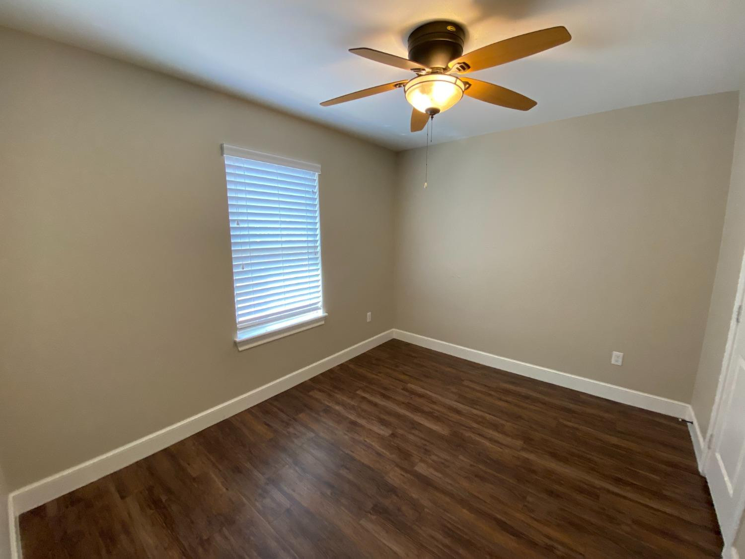 3235 64th Street Lubbock, TX 79413 - Photo 7 of 11 wooden floor in an empty room with a window