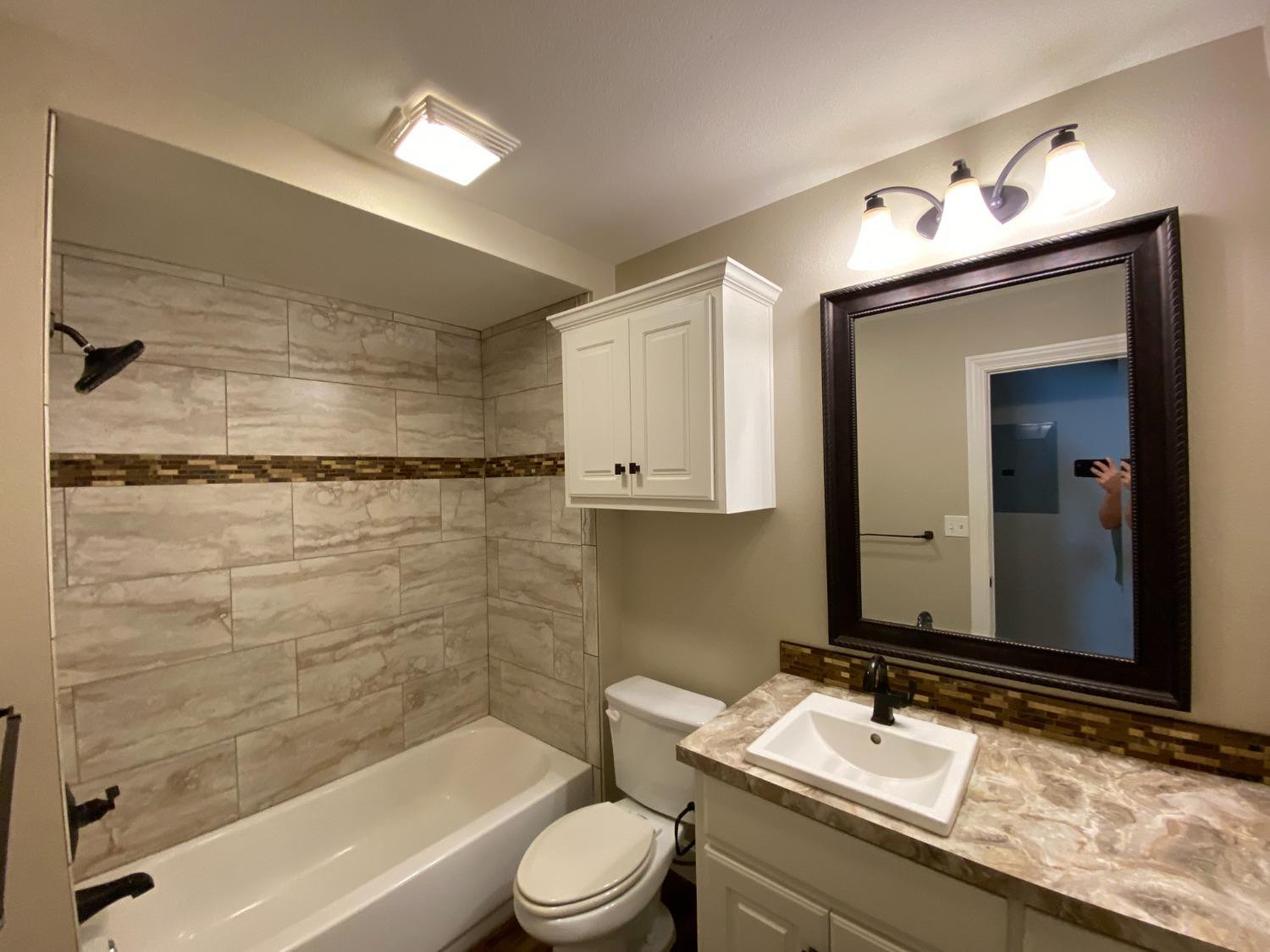 3235 64th Street Lubbock, TX 79413 - Photo 10 of 11 a bathroom with a sink vanity granite toilet tub and shower