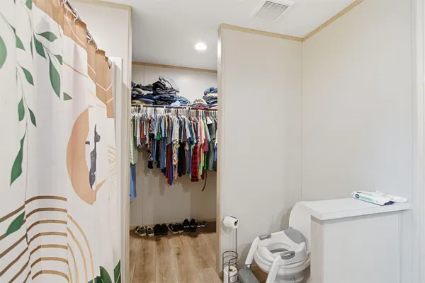 a view of walk in closet with clothes and shoes