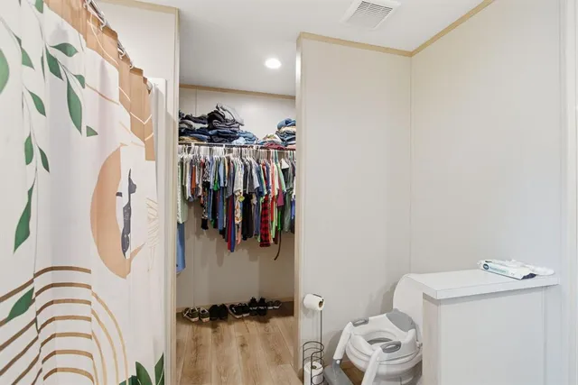 a view of walk in closet with clothes and shoes