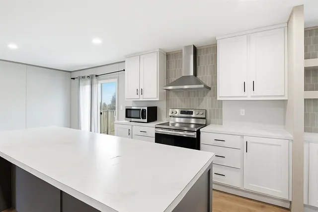 a kitchen with white cabinets and stainless steel appliances