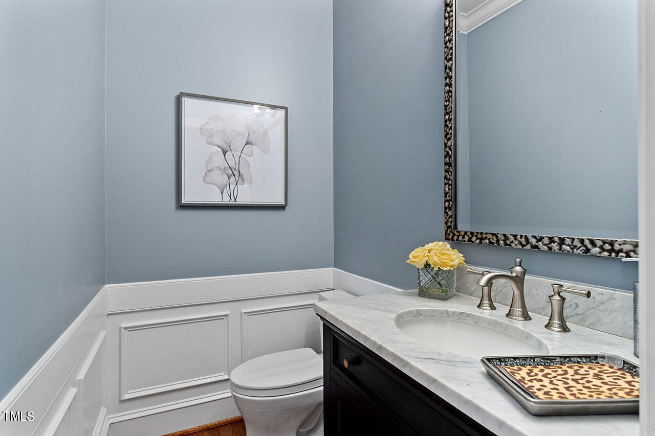 2408 Heartley Drive Raleigh, NC 27615 - Photo 20 of 41 a bathroom with a granite countertop toilet a sink and a mirror