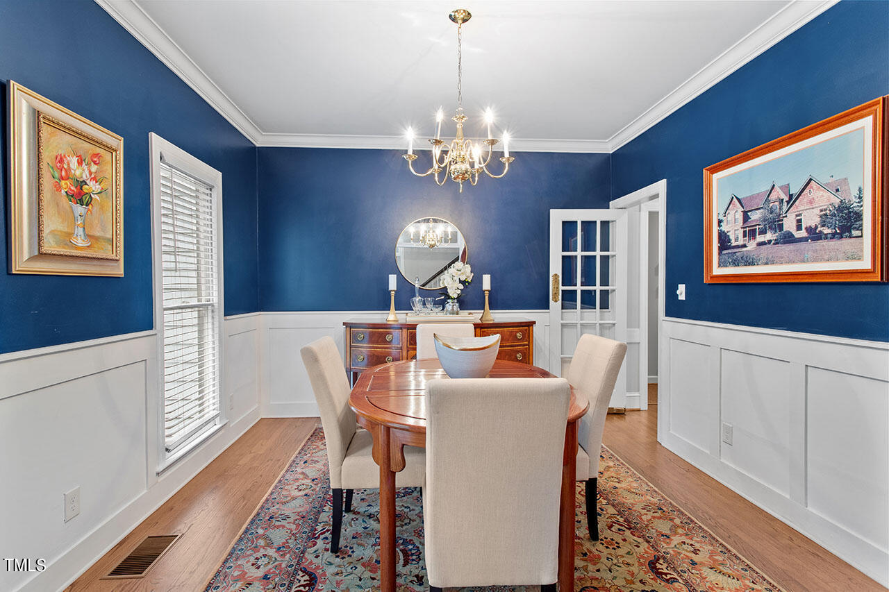 2408 Heartley Drive Raleigh, NC 27615 - Photo 22 of 41 a view of a dining room with furniture a chandelier and wooden floor