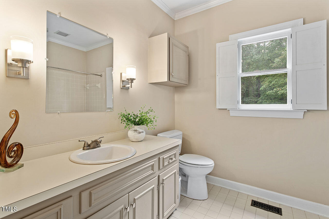 2408 Heartley Drive Raleigh, NC 27615 - Photo 25 of 41 a bathroom with a granite countertop sink and a toilet