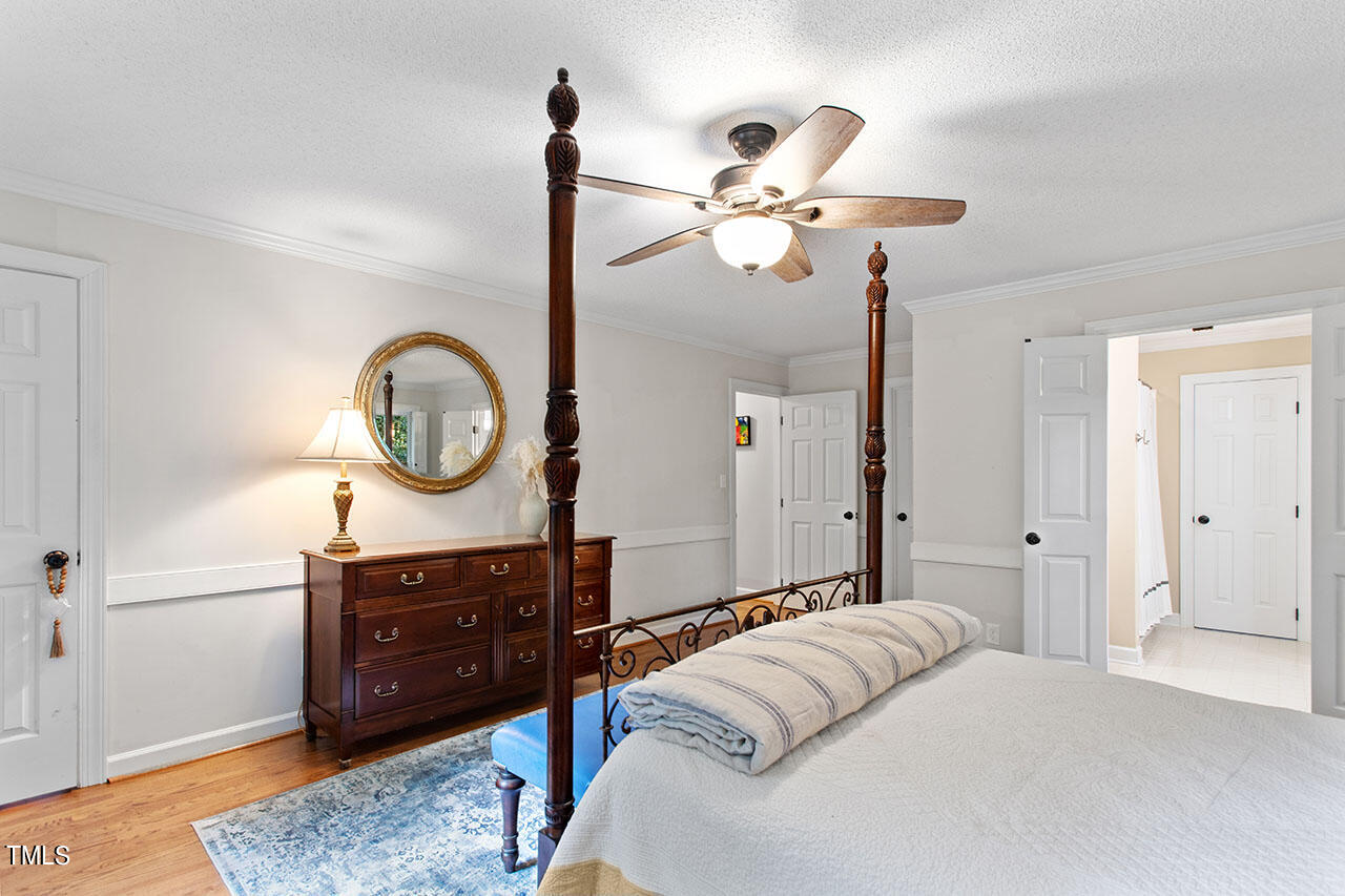 2408 Heartley Drive Raleigh, NC 27615 - Photo 28 of 41 a bedroom with a bed a chandelier and a mirror on dresser