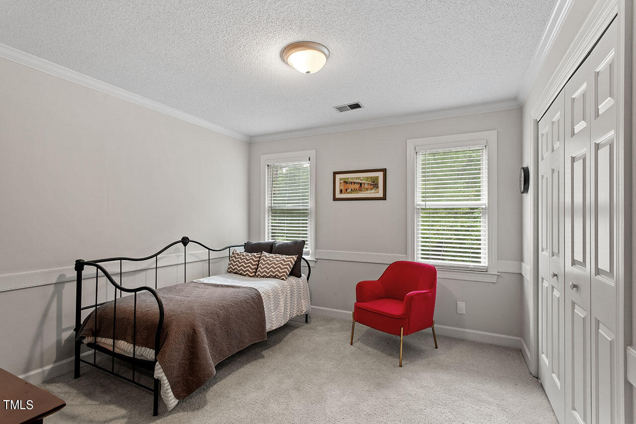 2408 Heartley Drive Raleigh, NC 27615 - Photo 30 of 41 a bedroom with a bed and chair