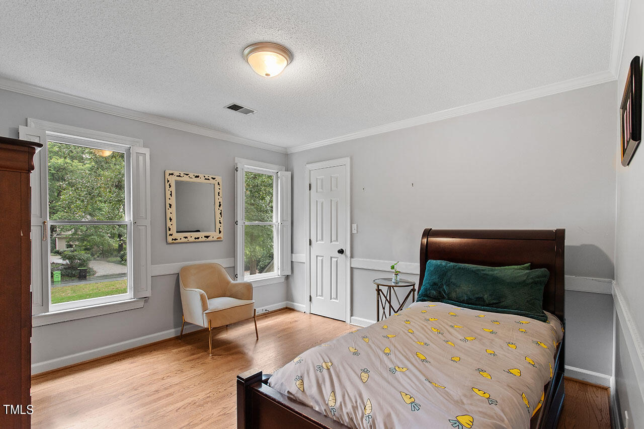 2408 Heartley Drive Raleigh, NC 27615 - Photo 31 of 41 a bedroom with a bed and wooden floor