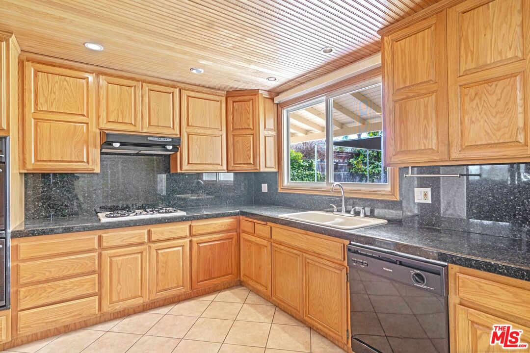 5703 Parkmor Road Calabasas, CA 91302 - Photo 14 of 29 a kitchen with granite countertop a sink window and cabinets