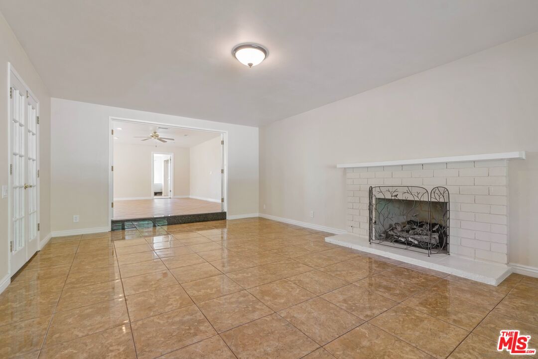 5703 Parkmor Road Calabasas, CA 91302 - Photo 10 of 29 an empty room with fireplace and windows