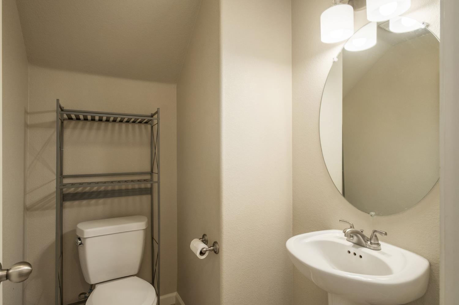 3482 Elevations Way Clovis, CA 93619 - Photo 14 of 29 a bathroom with a toilet sink and mirror