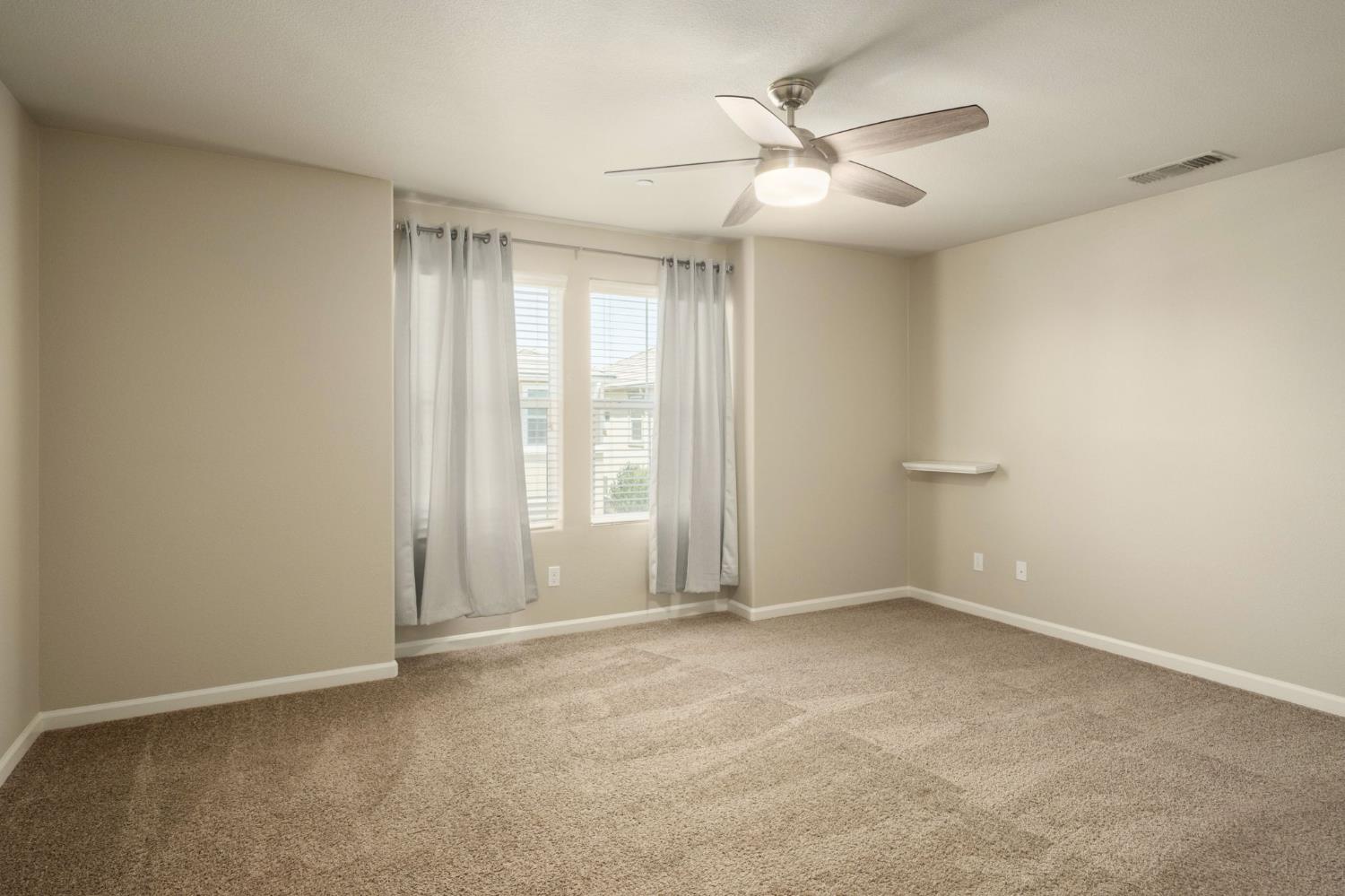 3482 Elevations Way Clovis, CA 93619 - Photo 18 of 29 an empty room with windows and fan