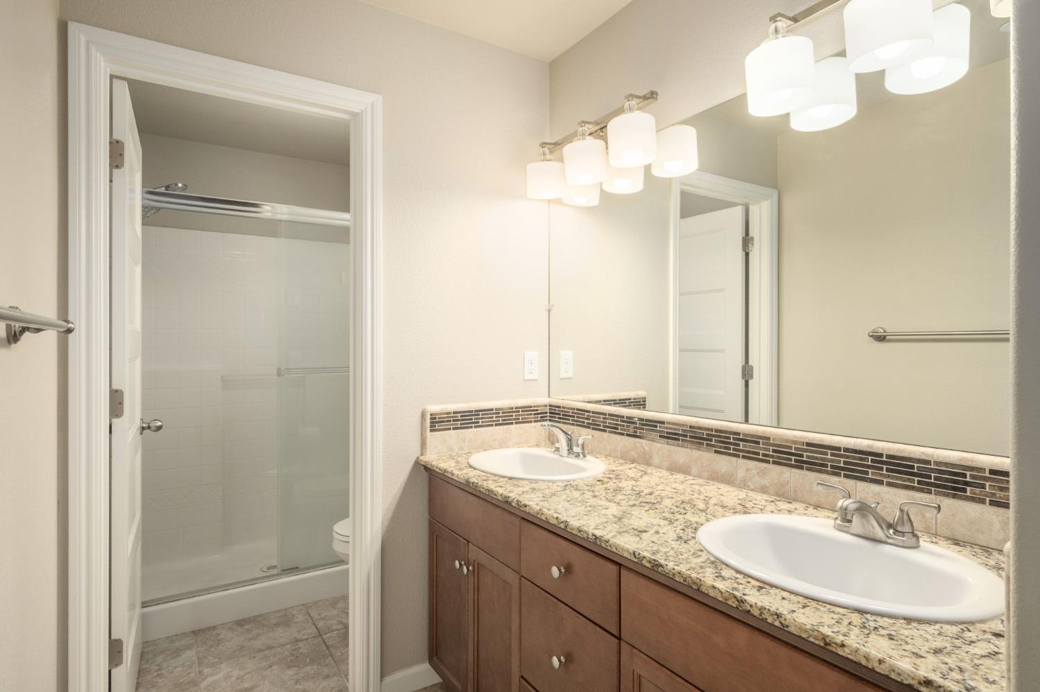 3482 Elevations Way Clovis, CA 93619 - Photo 19 of 29 a bathroom with a granite countertop sink and a mirror