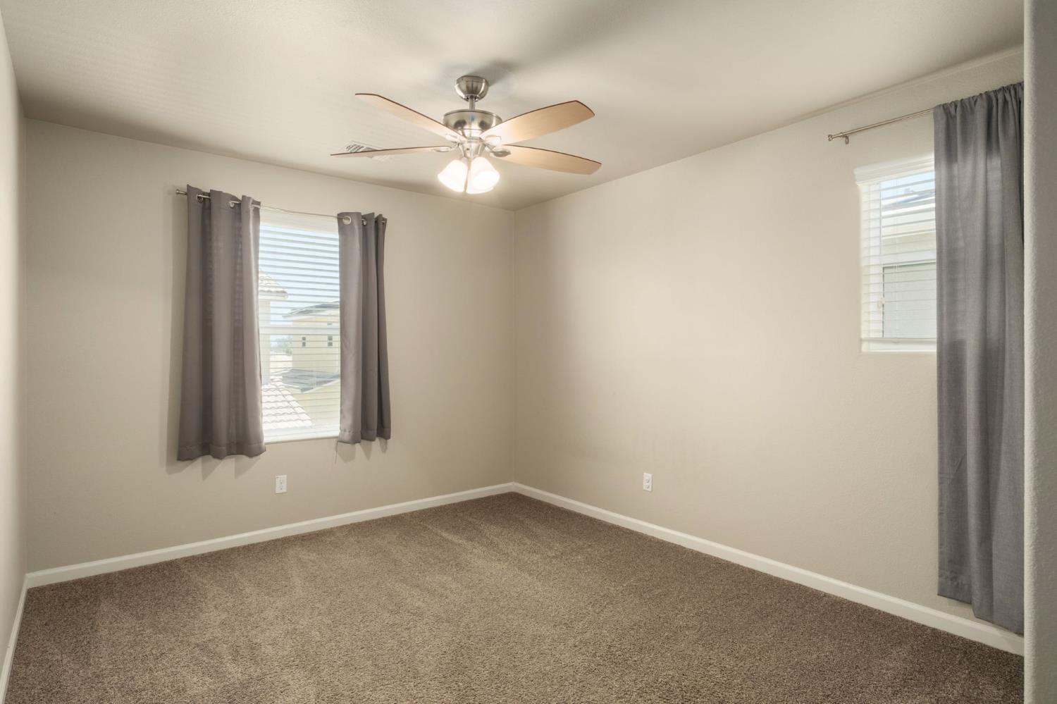 3482 Elevations Way Clovis, CA 93619 - Photo 20 of 29 an empty room with windows and fan