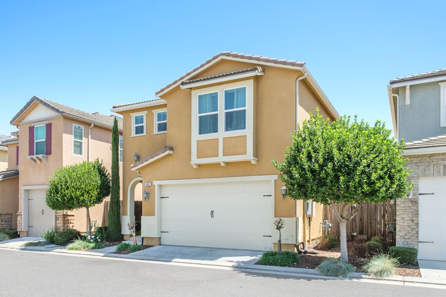 3482 Elevations Way Clovis, CA 93619 - Photo 3 of 29 a front view of a house with a yard and garage