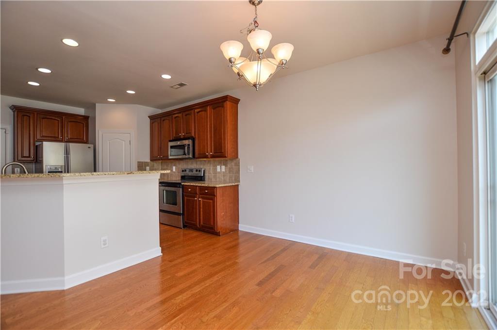 12110 Red Rust Lane Charlotte, NC 28277 - Photo 15 of 36 a kitchen with stainless steel appliances granite countertop a refrigerator a sink dishwasher a stove and white cabinets with wooden floor