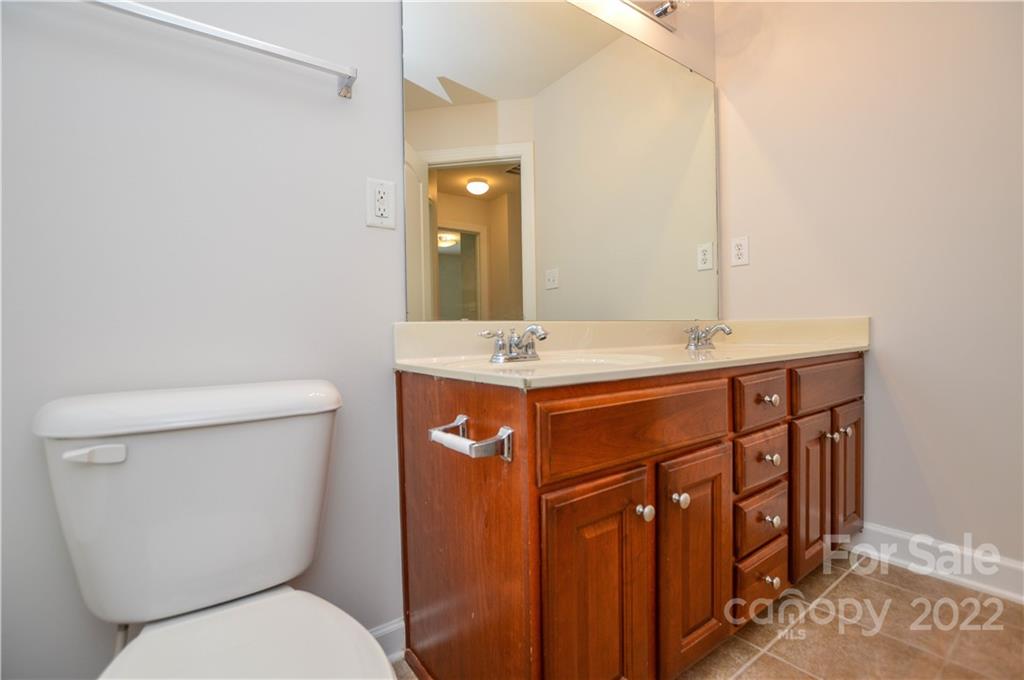 12110 Red Rust Lane Charlotte, NC 28277 - Photo 24 of 36 a bathroom with a toilet a sink and a mirror
