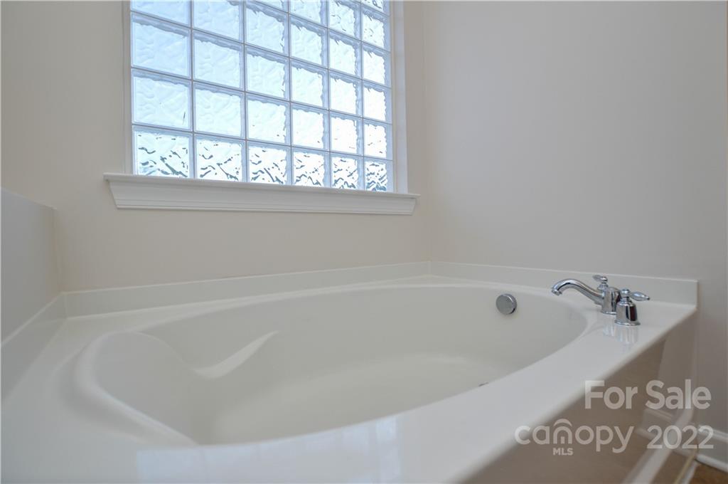 12110 Red Rust Lane Charlotte, NC 28277 - Photo 32 of 36 a white bath tub sitting next to a window