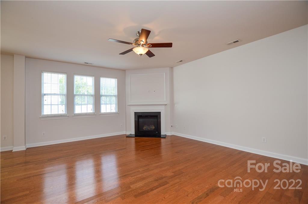 12110 Red Rust Lane Charlotte, NC 28277 - Photo 6 of 36 a view of empty room with wooden floor and fan
