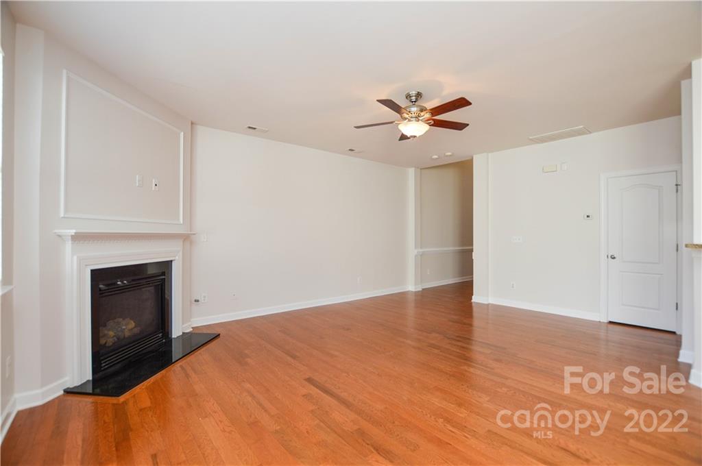 12110 Red Rust Lane Charlotte, NC 28277 - Photo 7 of 36 wooden floor in an empty room with a fireplace