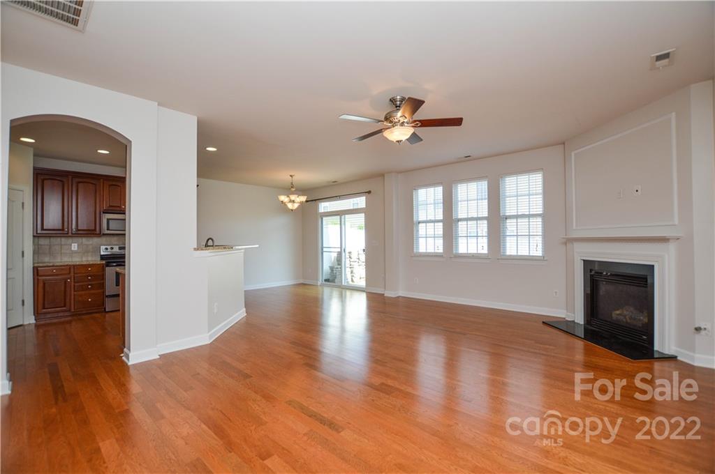 12110 Red Rust Lane Charlotte, NC 28277 - Photo 9 of 36 a view of an empty room with a kitchen and a fireplace