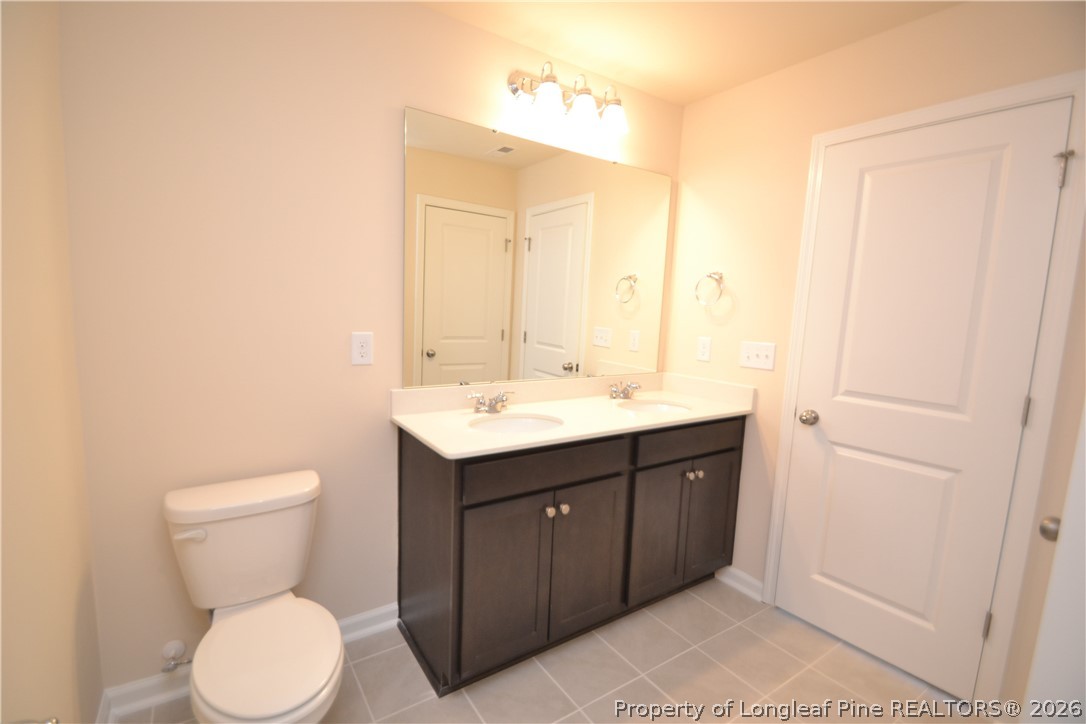 5703 Preveza Place Raleigh, NC 27603 - Photo 30 of 33 a bathroom with a toilet sink and mirror