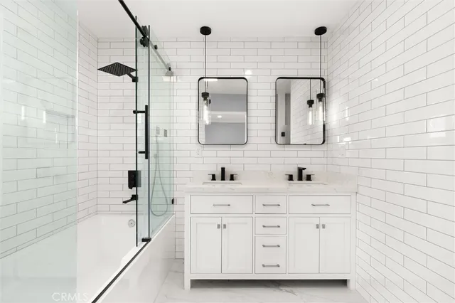 a bathroom with a double vanity sink a mirror and bathtub