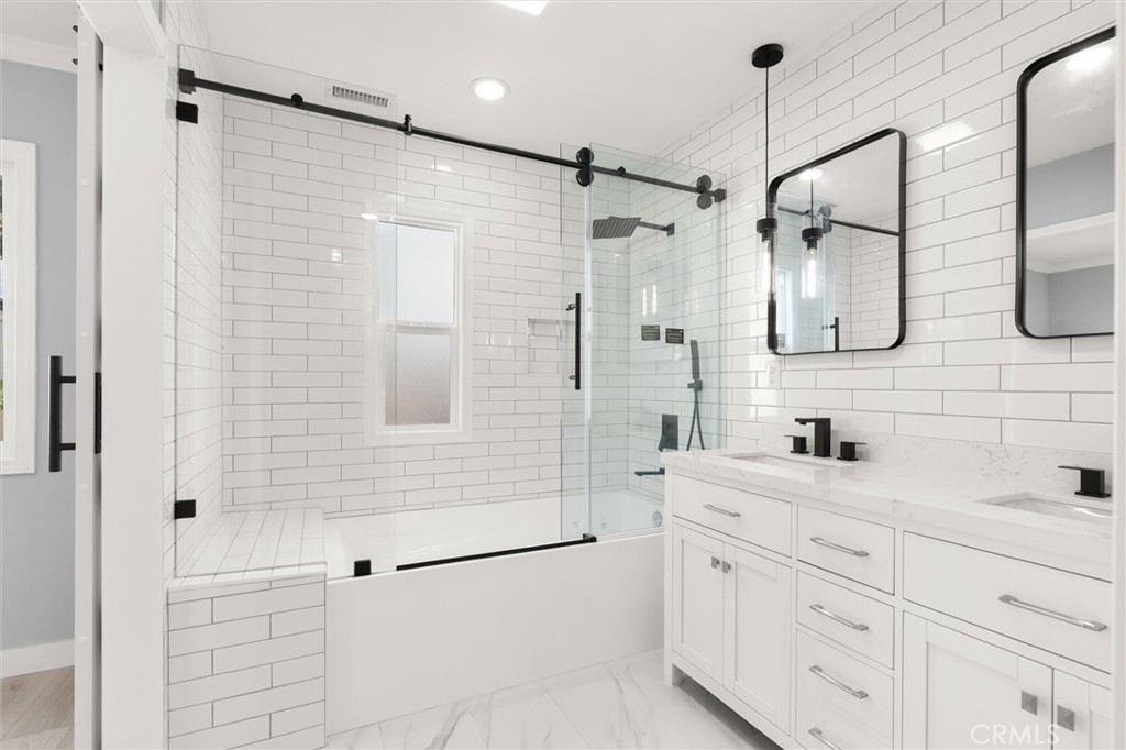 8460 Truxton Avenue Los Angeles, CA 90045 - Photo 25 of 41 a bathroom with a double vanity sink a mirror a shower and a bathtub
