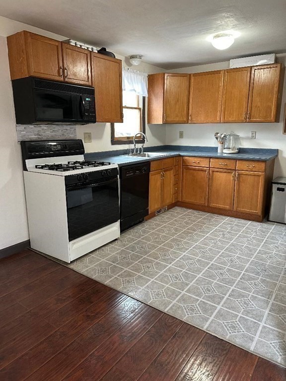 210 3rd Street Lowell, MA 01850 - Photo 11 of 18 a kitchen with stainless steel appliances granite countertop a stove a sink dishwasher and a microwave oven on the wooden floor
