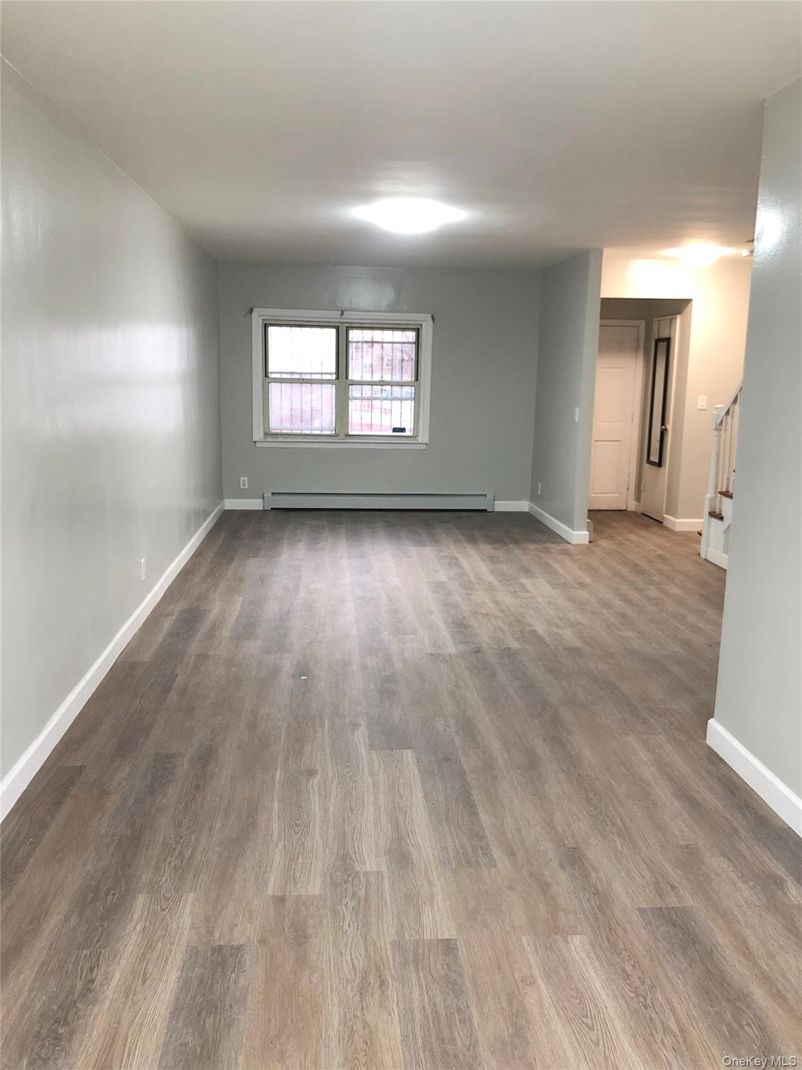 148-03 Horace Harding Expressway Queens, NY 11367 - Photo 3 of 18 wooden floor in an empty room with a window