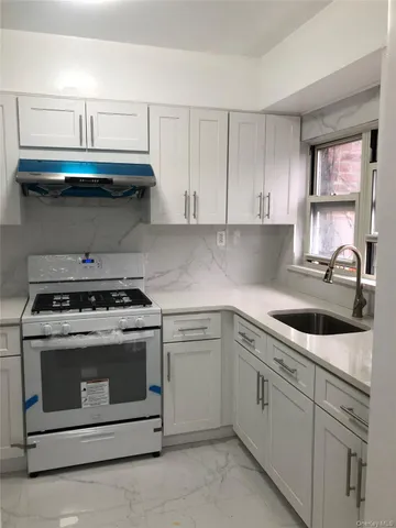 a kitchen with white cabinets and appliances
