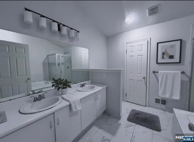 a bathroom with a sink double vanity tub and a mirror