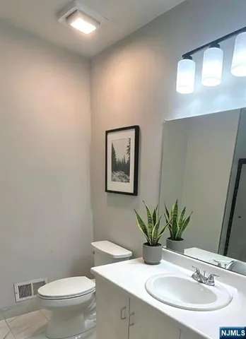 a bathroom with a toilet a sink and mirror