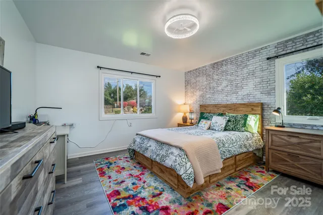 a bedroom with a bed and a dresser next to a window