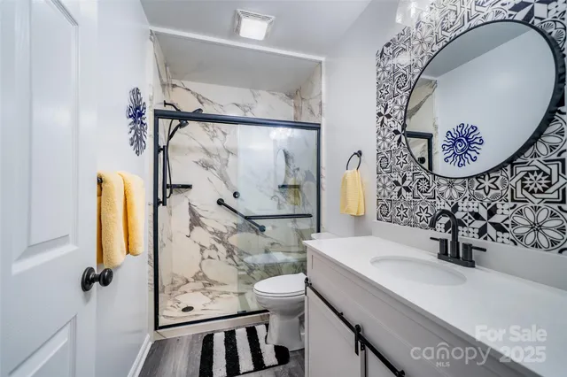 a bathroom with a sink mirror vanity and toilet
