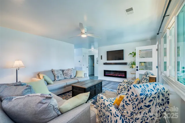 a living room with furniture a flat screen tv and a fireplace