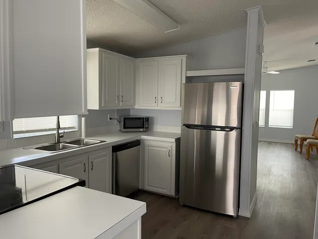 a kitchen with a refrigerator sink and cabinets