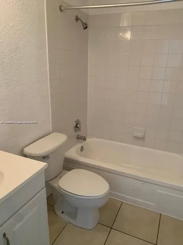 a white toilet and tub sitting next to a bathroom sink