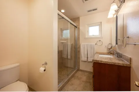 a bathroom with a granite countertop sink toilet and shower