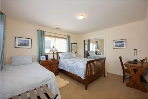 a bedroom with two beds and chair