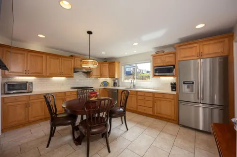 a kitchen with stainless steel appliances granite countertop a refrigerator a stove top oven a sink dishwasher and a refrigerator