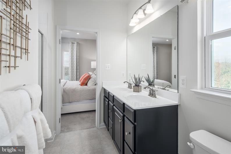 131 Drydock Way, Unit H Brooklyn, MD 21225 - Photo 9 of 13 a en suite bathroom with a double vanity sink and a mirror