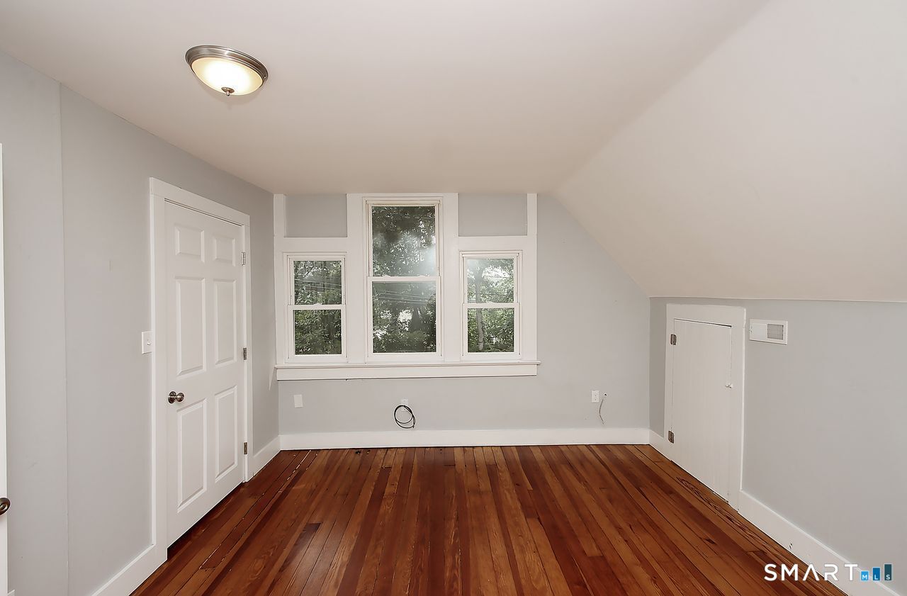 141 Duck Hole Road Madison, CT 06443 - Photo 18 of 22 an empty room with wooden floor and windows