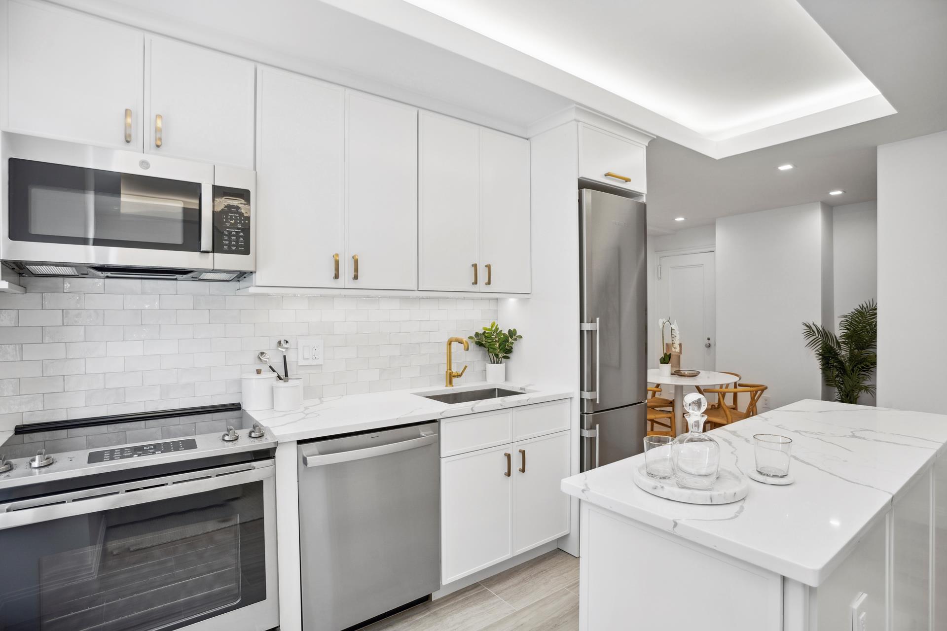 a kitchen with stainless steel appliances white cabinets and wooden floors