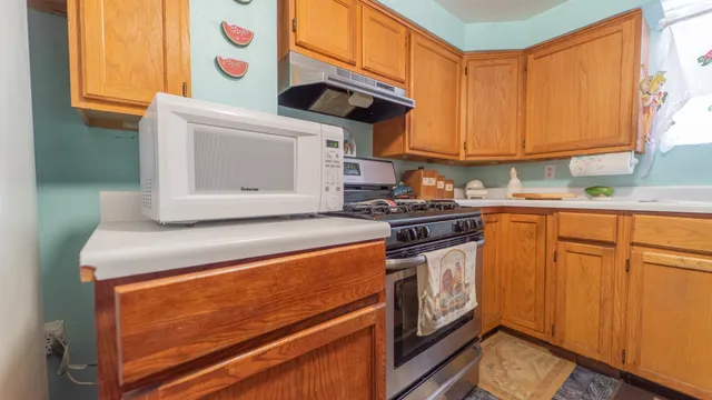 a kitchen with stainless steel appliances granite countertop a stove a sink and a microwave