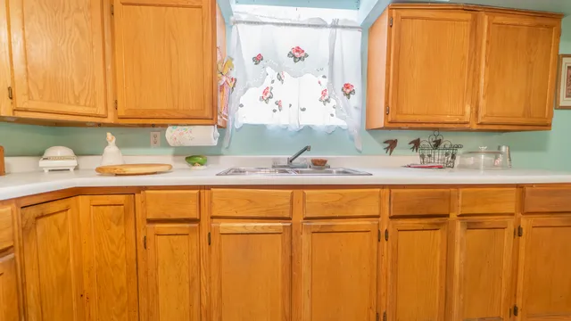a bathroom with a granite countertop sink and a window