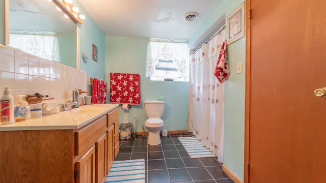 a bathroom with a sink a toilet and shower curtain